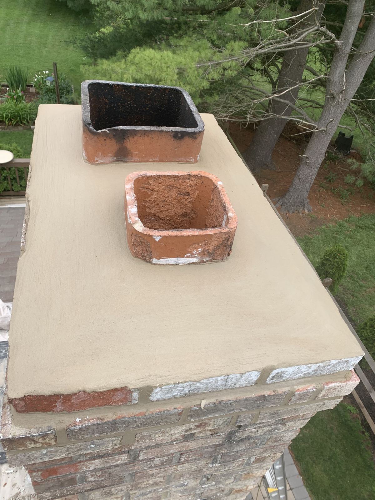 Repointed brick chimney crown with fresh mortar and parging